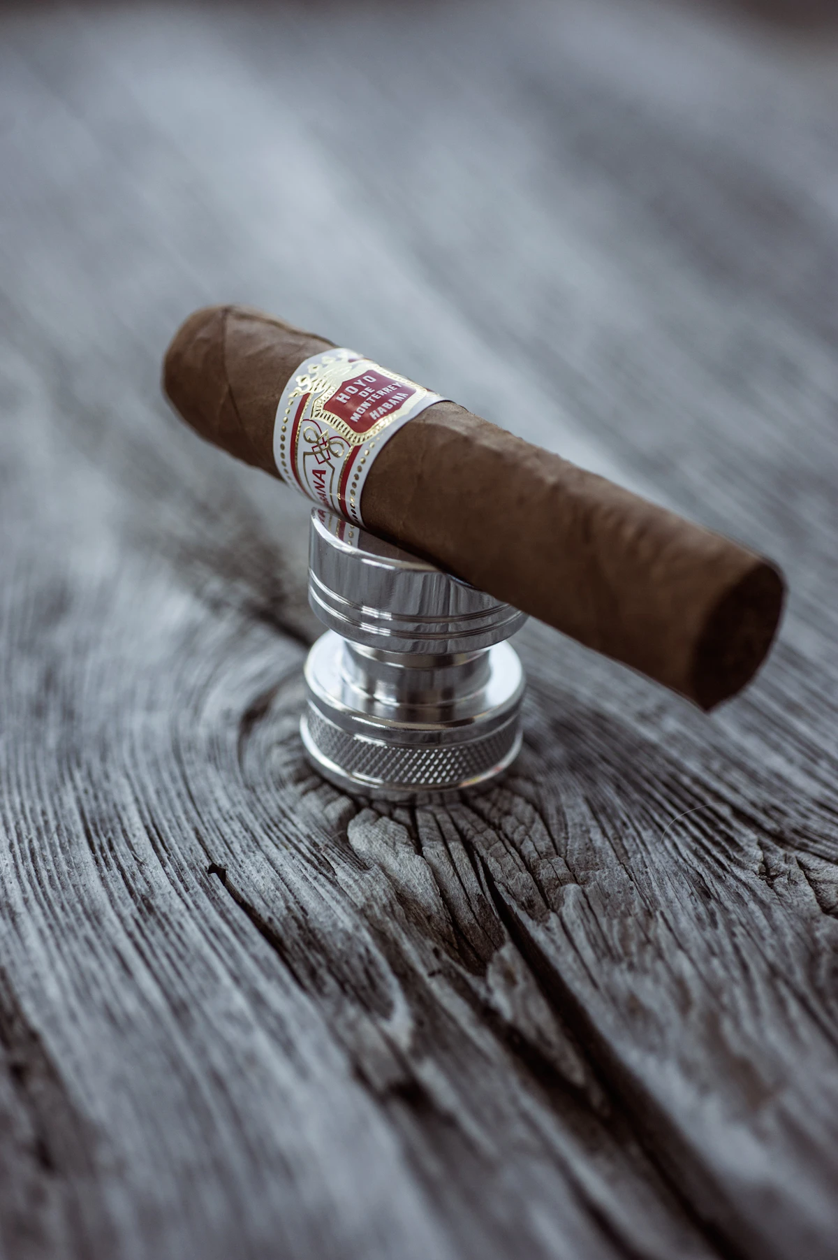 Close-up of a cigar with dark broadleaf wrapper against a black backdrop