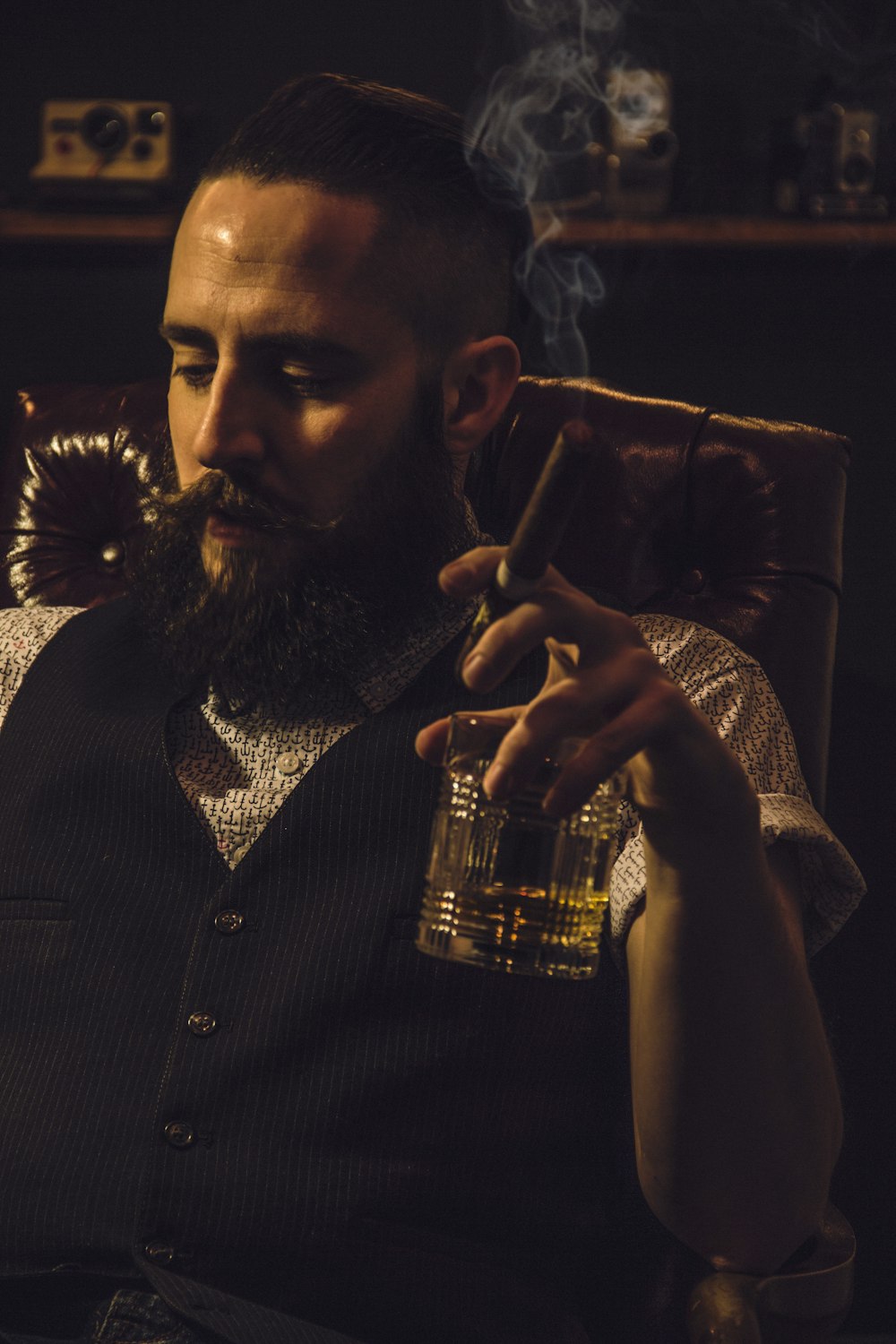 man in black and white polka dot button up shirt holding clear drinking glass