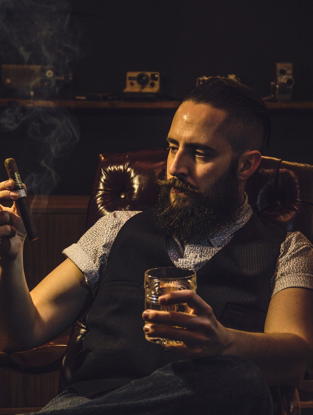 Hombre con camisa a cuadros blanco y negro sosteniendo un vaso transparente