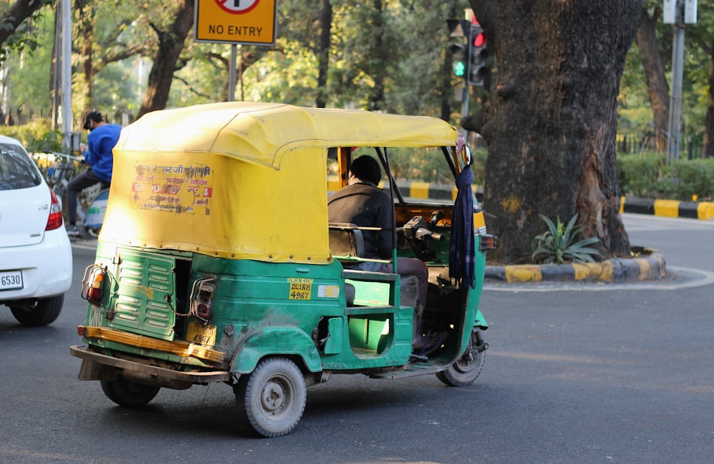 pousse-pousse automatique vert et jaune sur la route pendant la journée