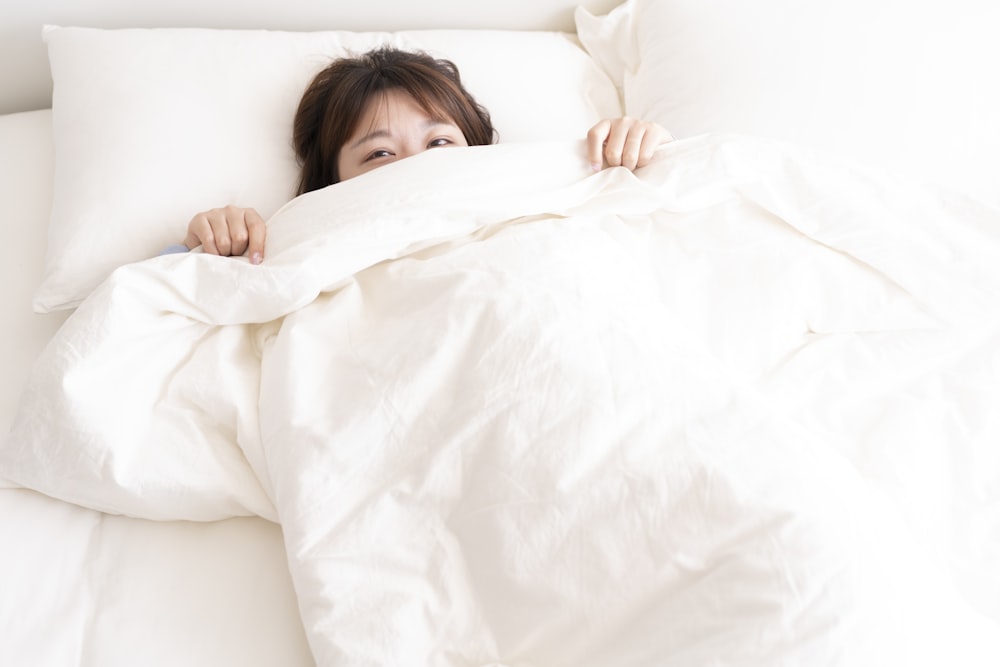 girl lying on white bed