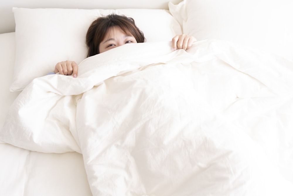 Foto Niña acostada en la cama blanca – Imagen Guangzhou gratis en Unsplash