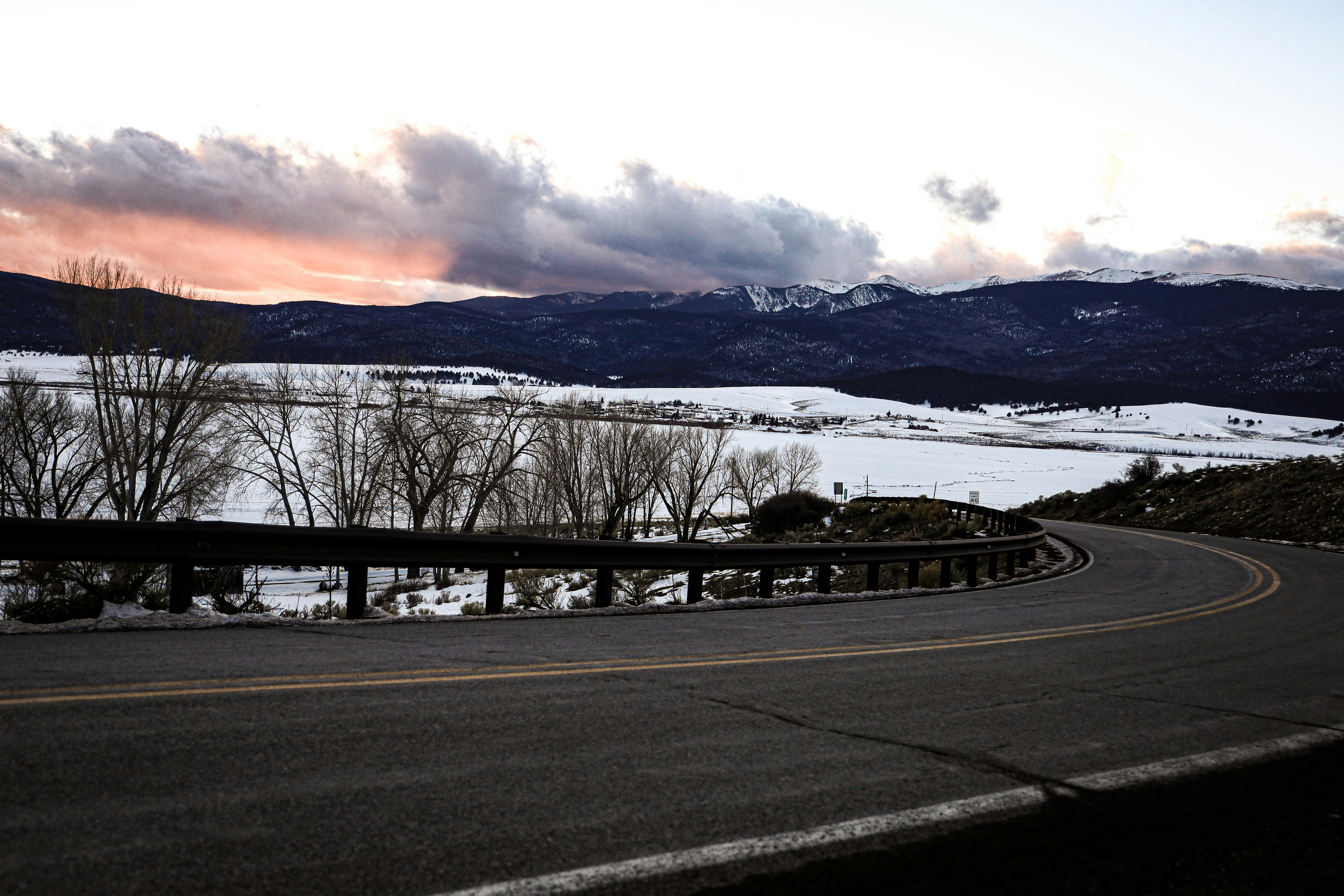 black asphalt road near snow covered mountain during daytime