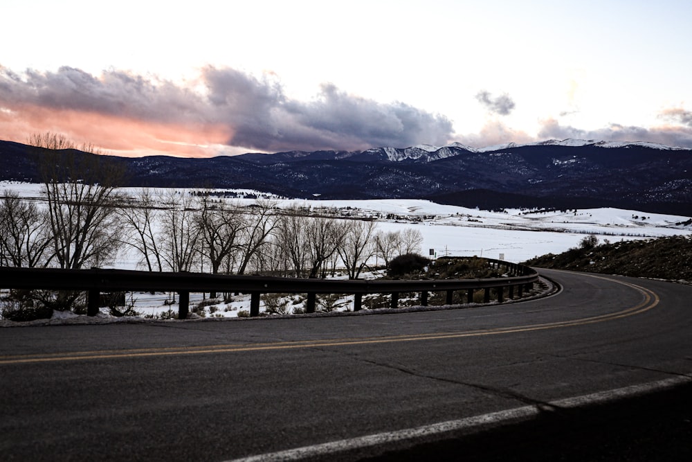 black asphalt road near snow covered mountain during daytime