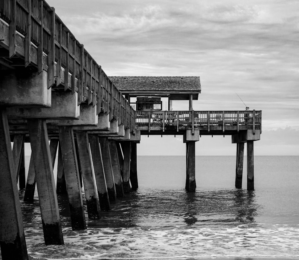 grayscale photo of wooden dock on body of water