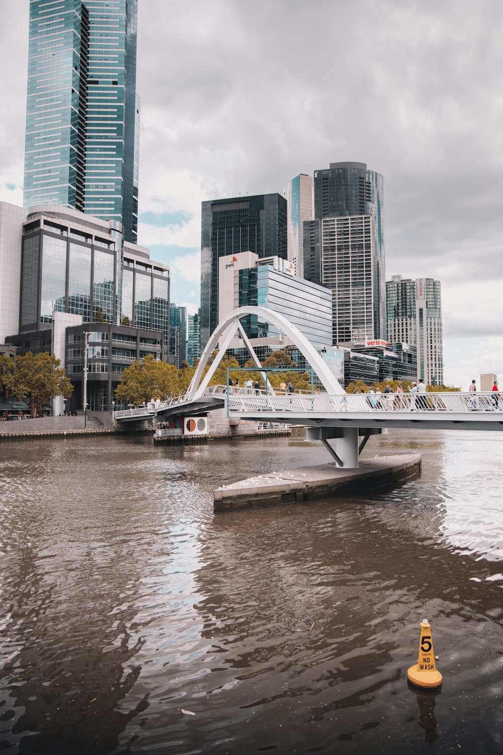 white bridge over river near city buildings during daytime