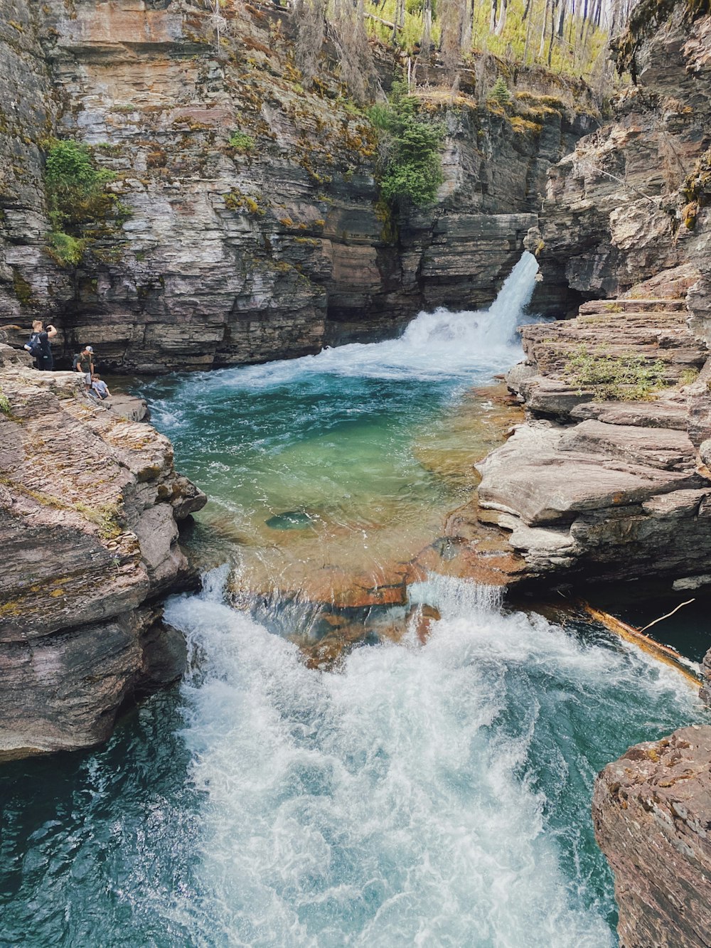 water falls on rocky mountain during daytime