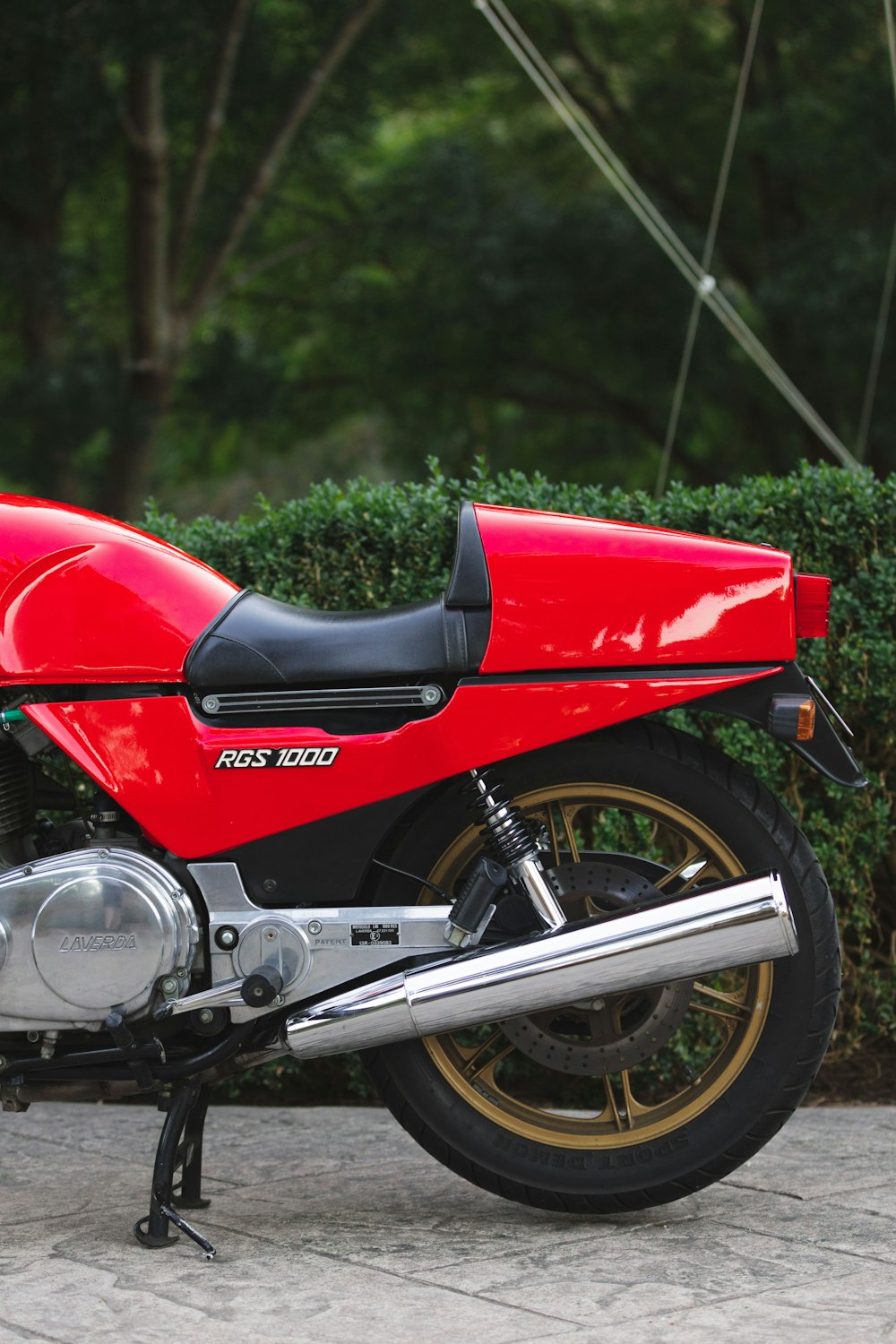 red and black motorcycle parked on green grass field during daytime