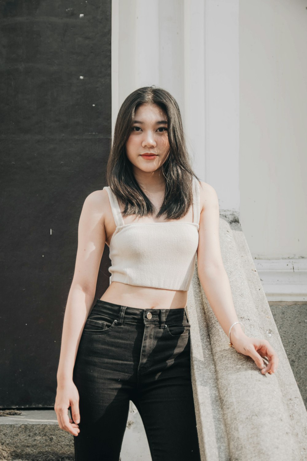 a woman standing next to a wall wearing a crop top
