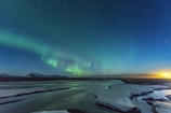 A breathtaking view of the Northern Lights over a snowy landscape.