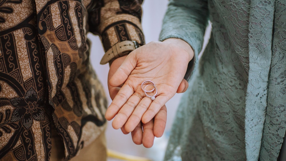 a close up of two people holding hands