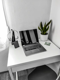 A minimalist workspace with a laptop, headphones, and a notebook, evoking creativity and focus.