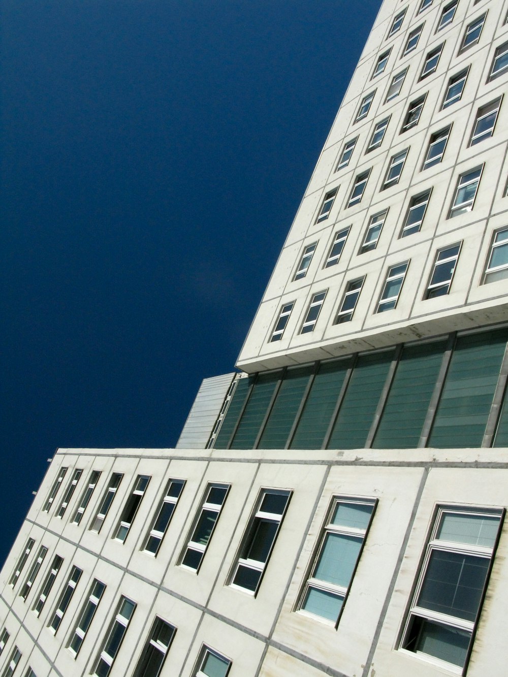 Bâtiment en béton blanc sous le ciel bleu pendant la journée