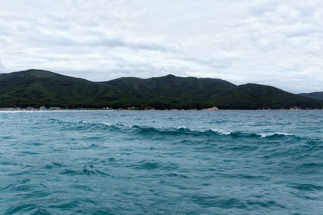 body of water near mountain during daytime