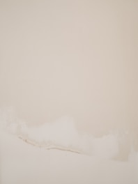 Large minimalist abstract painting with soft white and gray tones in a bright gallery space.