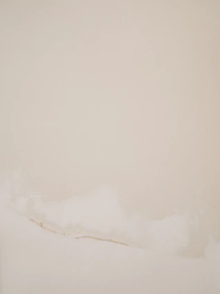 Minimalistic abstract art piece with soft gold and deep red geometric shapes on a light beige background.