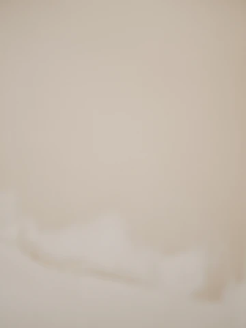 Soft textured background resembling gentle fabric in warm beige and ivory tones.