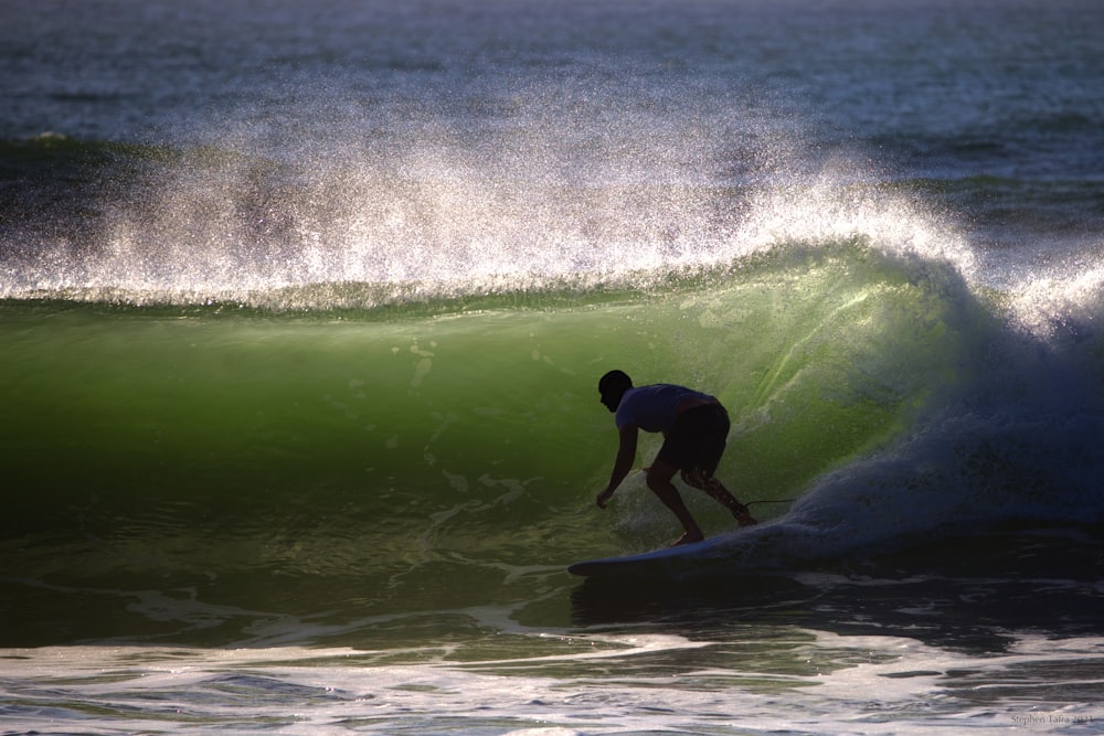 man in black wetsuit surfing on sea waves during daytime