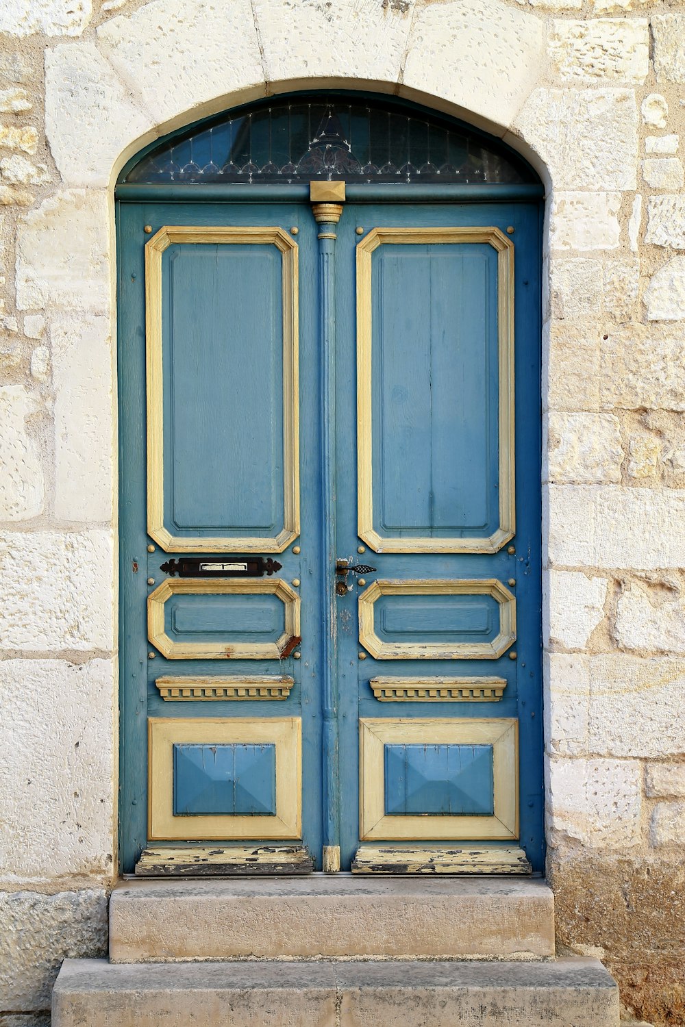 puerta de madera azul sobre pared de hormigón gris
