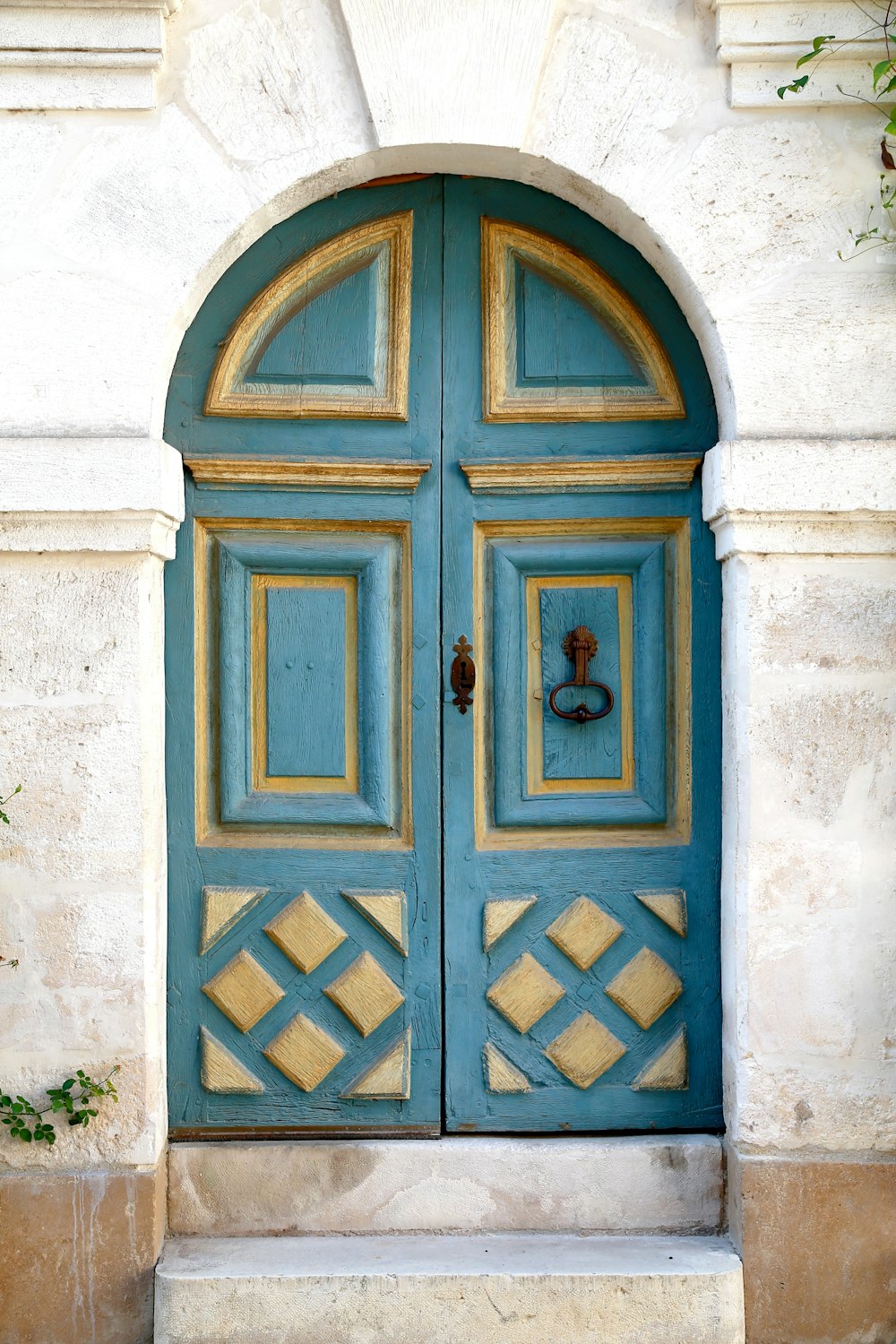 Porte en bois bleu sur mur en béton blanc