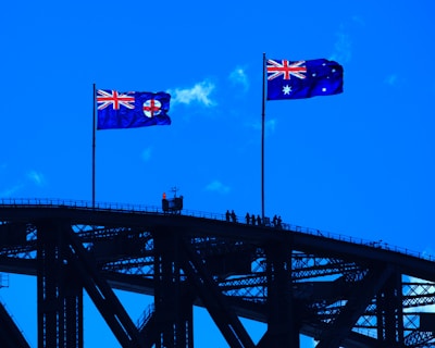 blue red and yellow flag on black metal bridge under blue sky during daytime