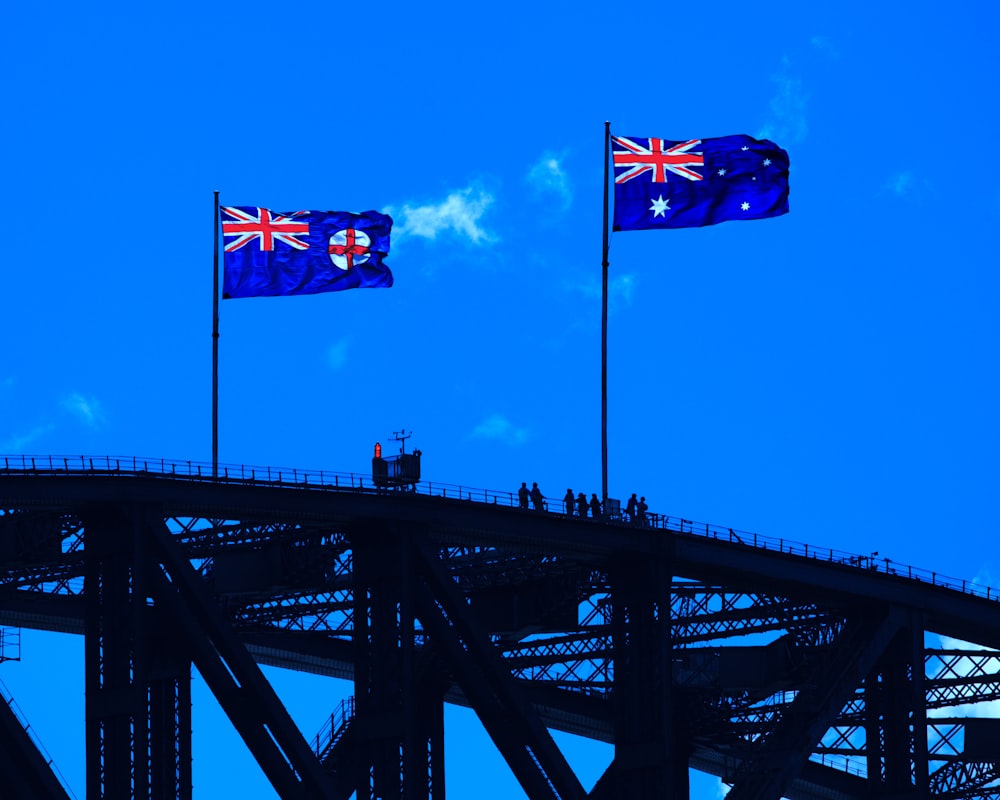 bandera azul, roja y amarilla en el puente de metal negro bajo el cielo azul durante el día