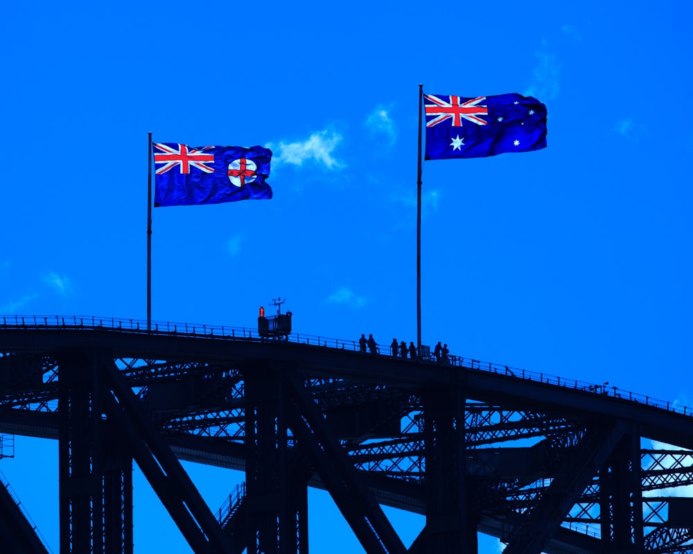 Drapeau bleu, rouge et jaune sur un pont en métal noir sous un ciel bleu pendant la journée