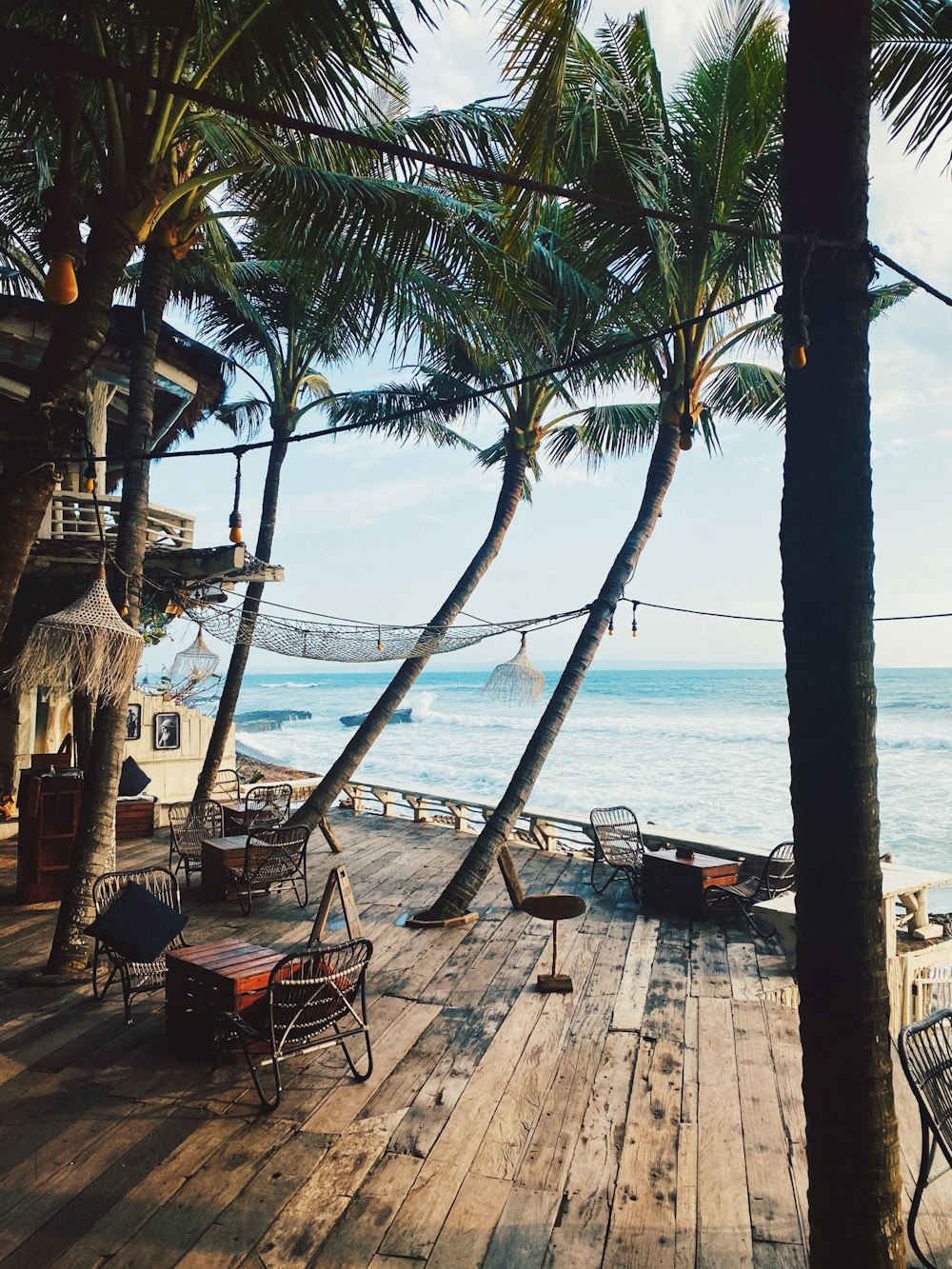 brown wooden chairs on brown wooden dock near body of water during daytime