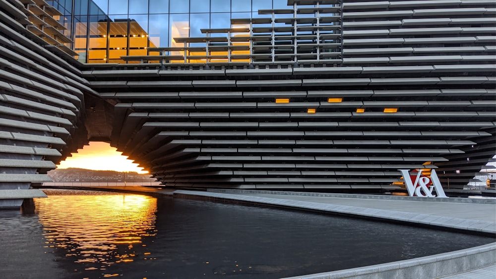 gray metal frame on body of water during sunset