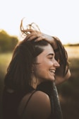 Woman with freshly styled balayage hair smiling in natural light.