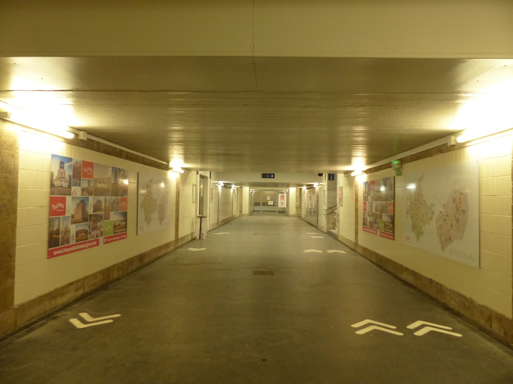 an empty parking garage with posters on the walls