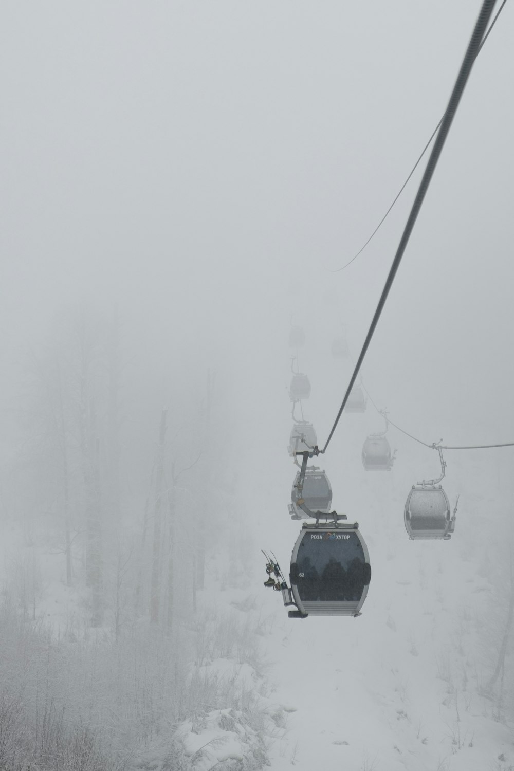 teleférico preto no chão coberto de neve durante o dia