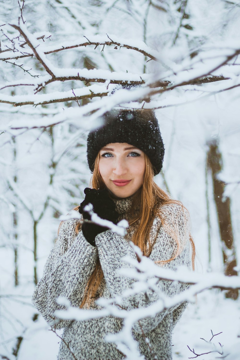 woman in white and black coat and black knit cap standing on snow covered ground during