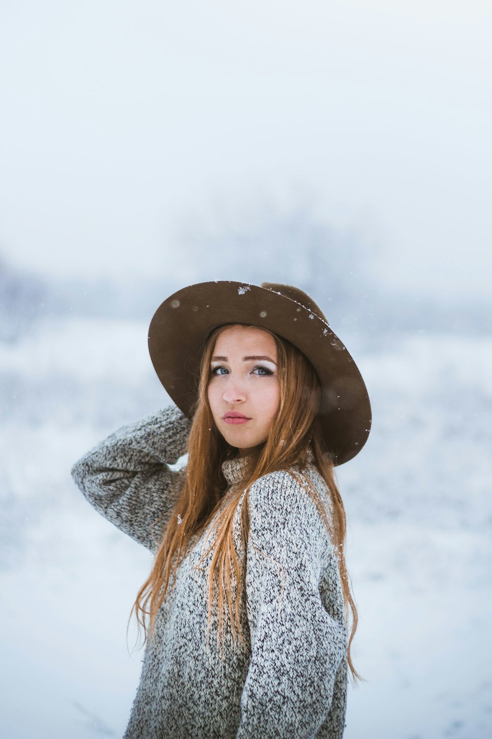 woman in brown hat and white and blue knitted sweater