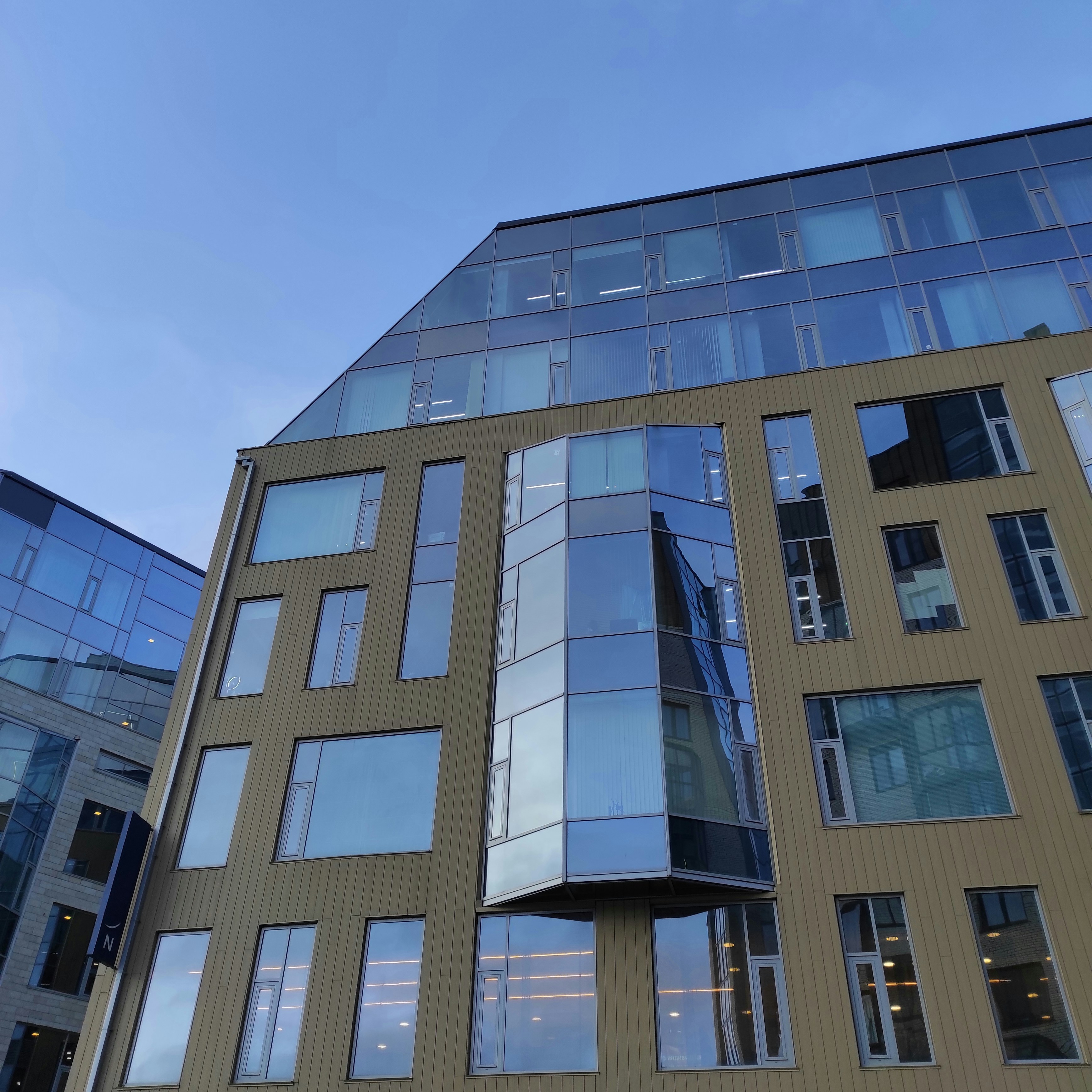 Staklena aluminijumska fasada moderne poslovne zgrade, refleksija neba