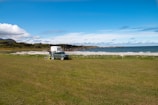 An RV parked at a beachside campsite with waves gently rolling in nearby.
