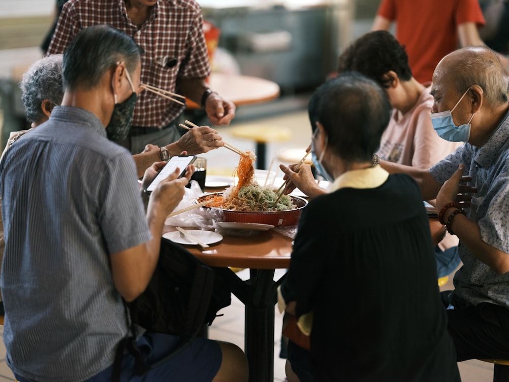 茶色の木製のテーブルで食事をする人々