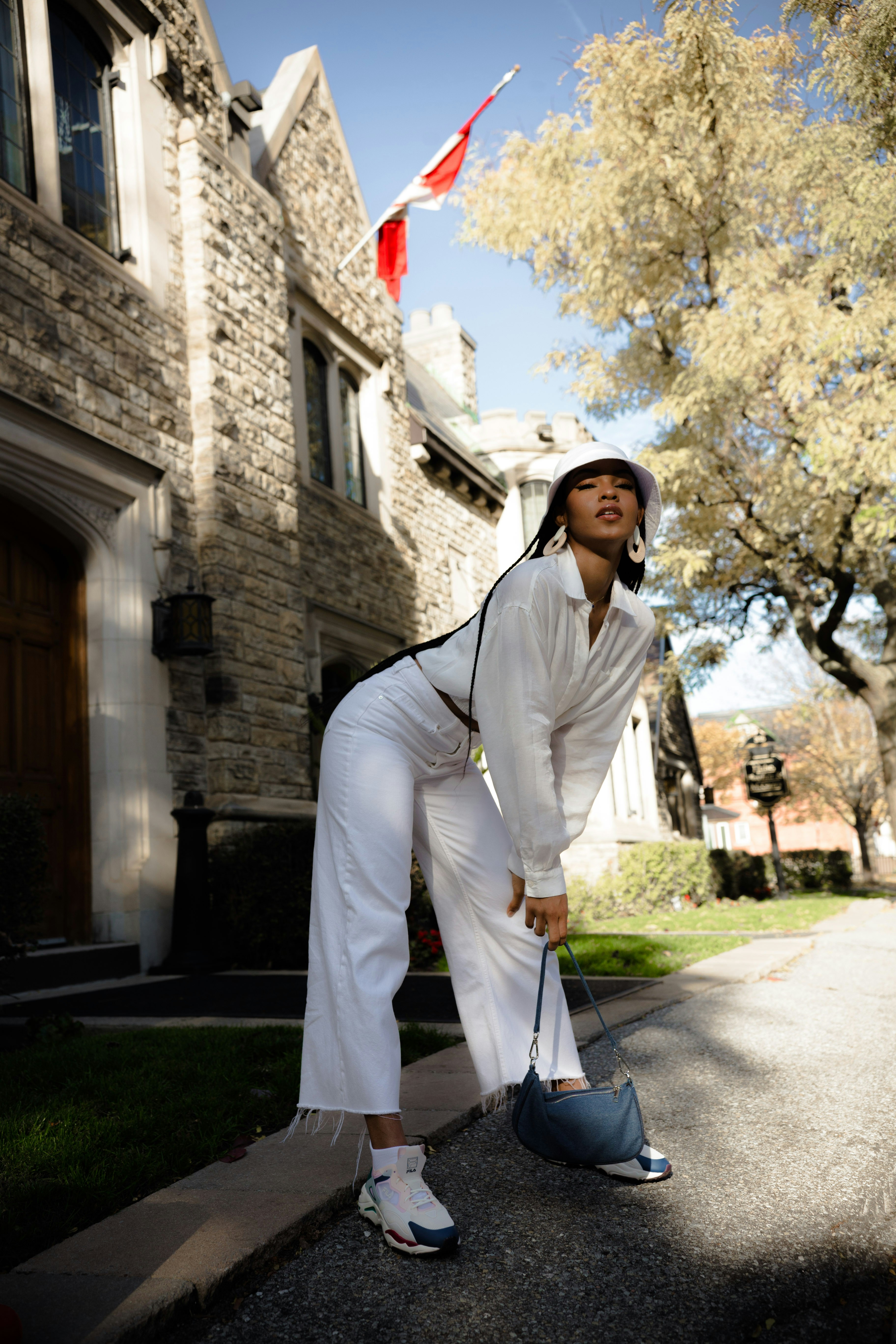 woman in white long sleeve dress standing on sidewalk during daytime