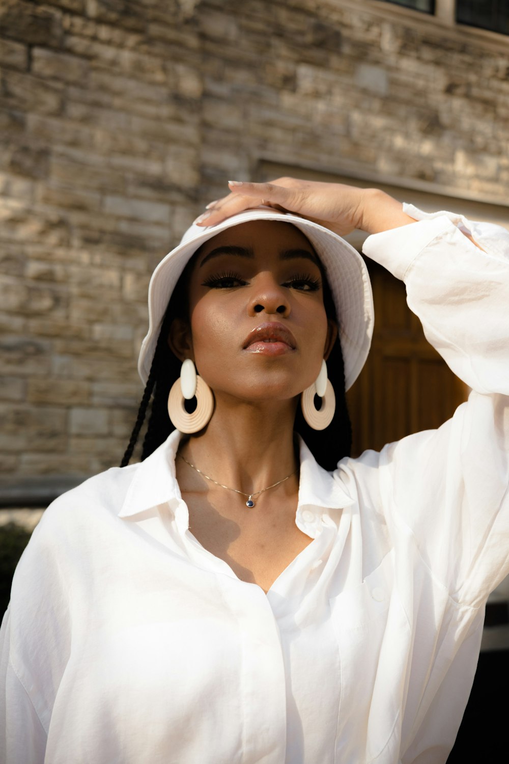 woman in white button up shirt wearing white and brown hat