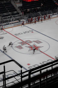 The team practicing a synchronized routine on a pristine ice rink with light reflecting off the surface.