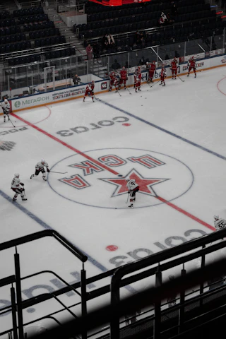 The team practicing a synchronized routine on a pristine ice rink with light reflecting off the surface.