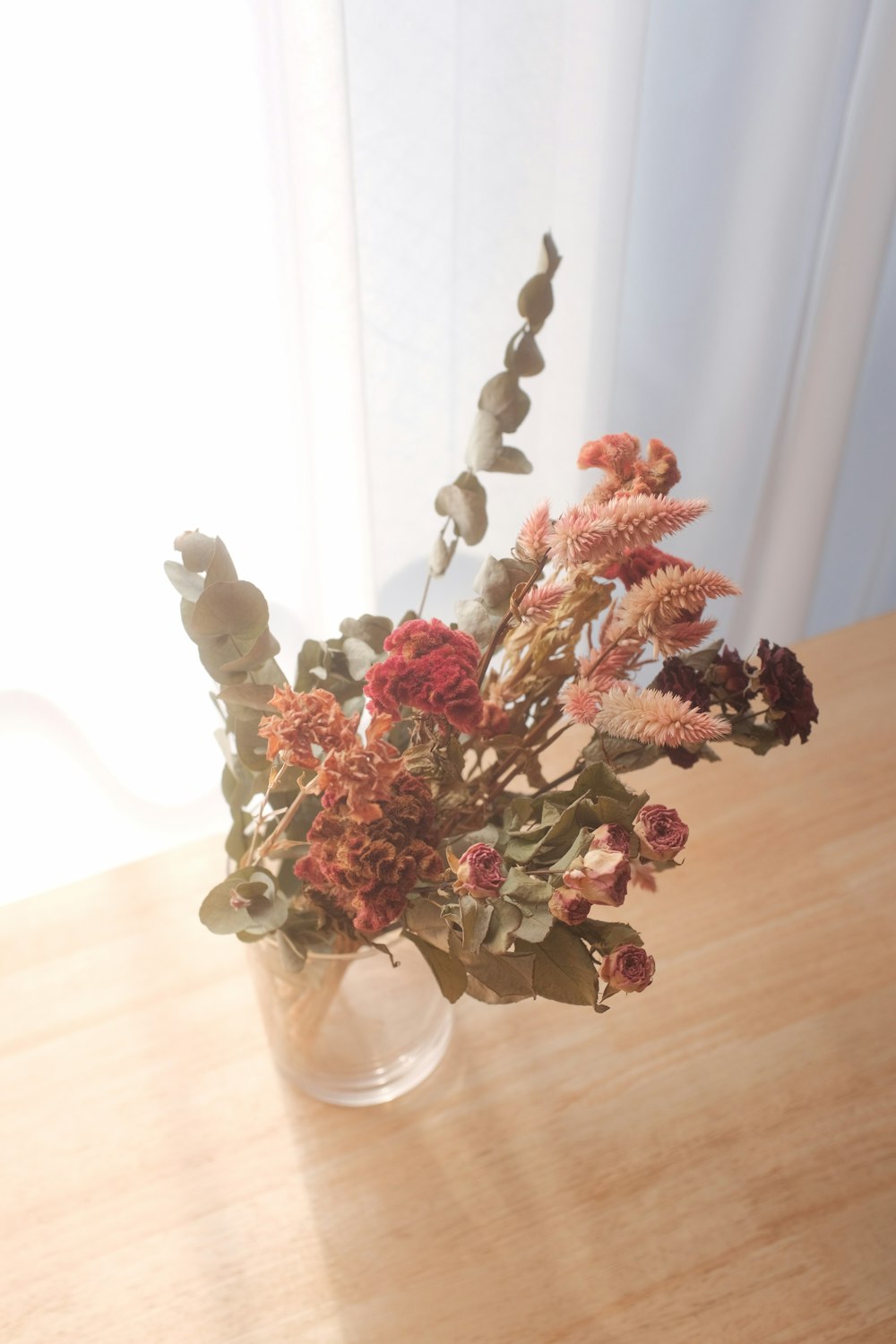 pink and white flower bouquet in clear glass vase