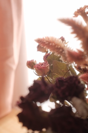 Close-up of a delicate dried flower rosary glowing softly in natural light.