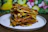 Close-up of a colorful gluten-free lasagna served on a rustic wooden table.