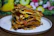 Close-up of a colorful gluten-free lasagna served on a rustic wooden table.
