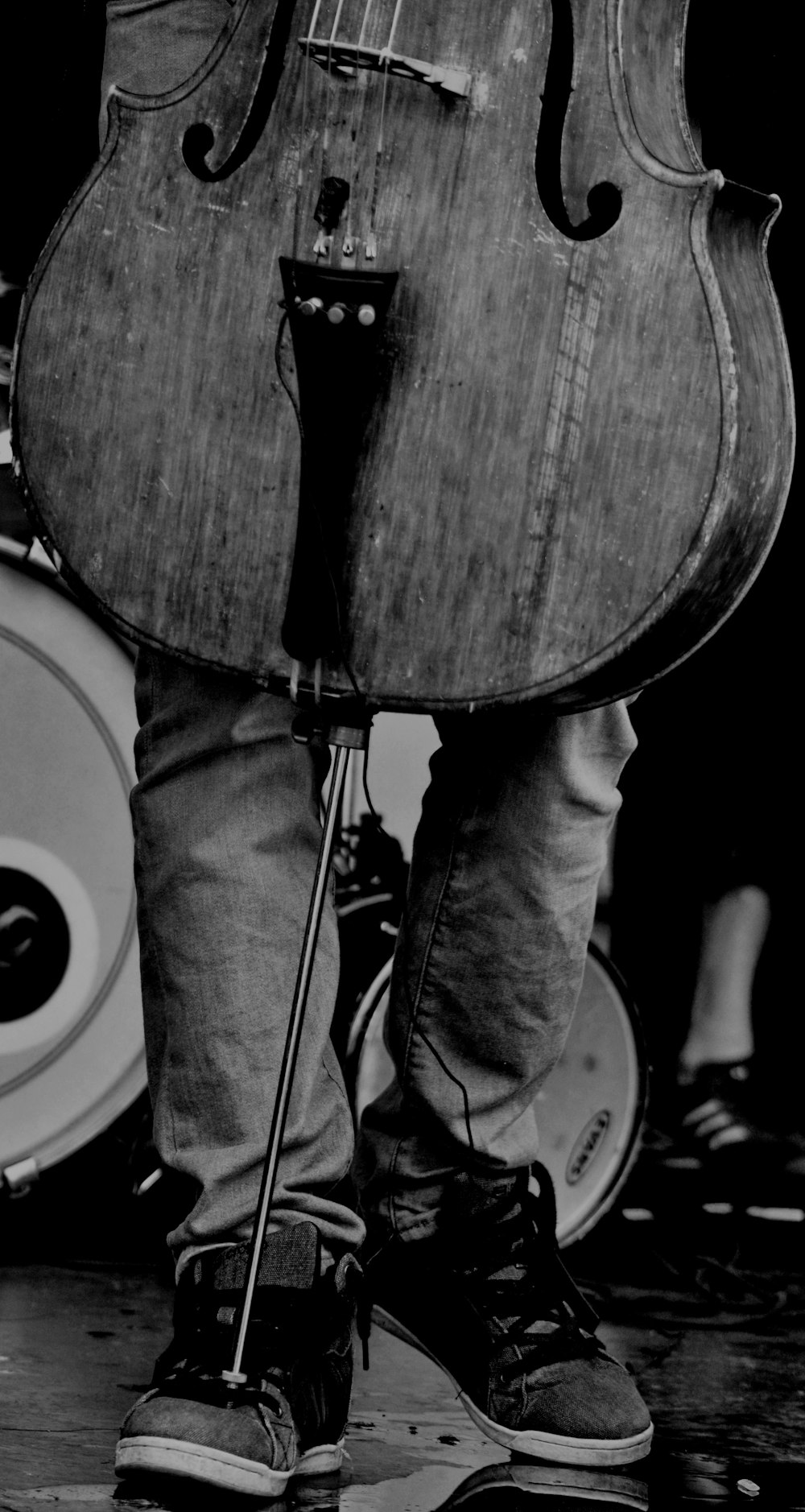 person in black denim jeans standing beside drum set