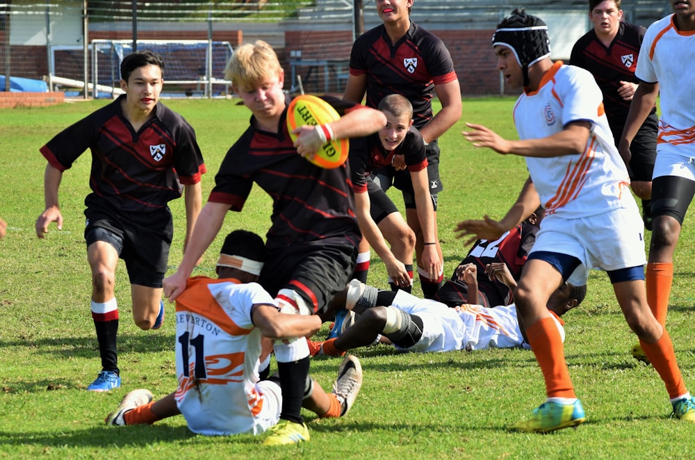 group of men playing soccer on field during daytime