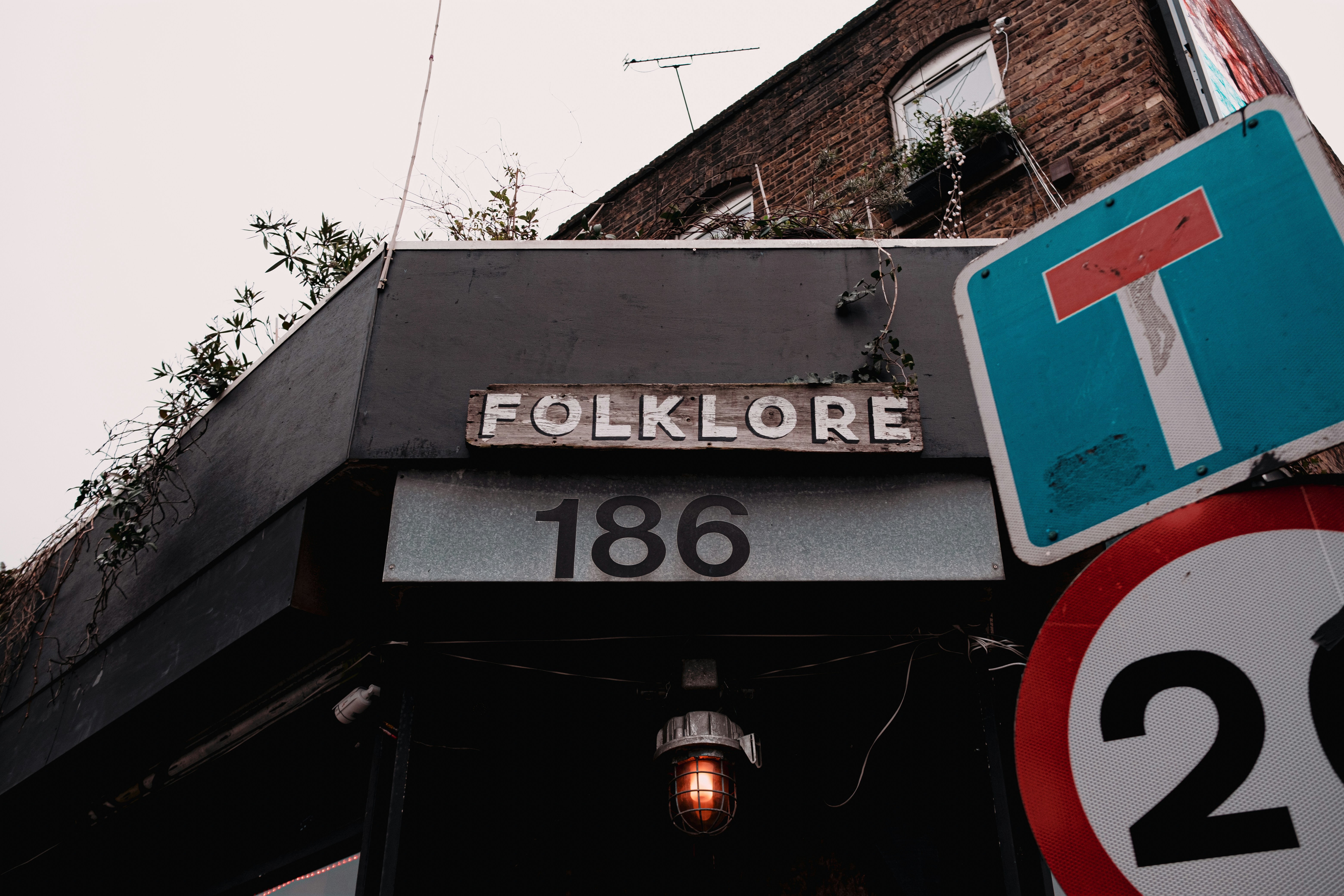 a street sign and a traffic sign in front of a brick building