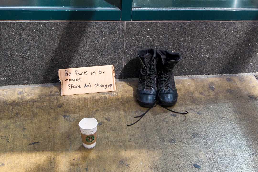 black leather boots beside white and black coffee cup