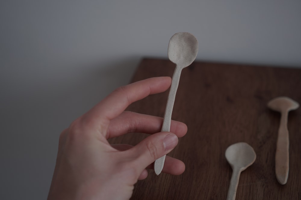 person holding white plastic spoon